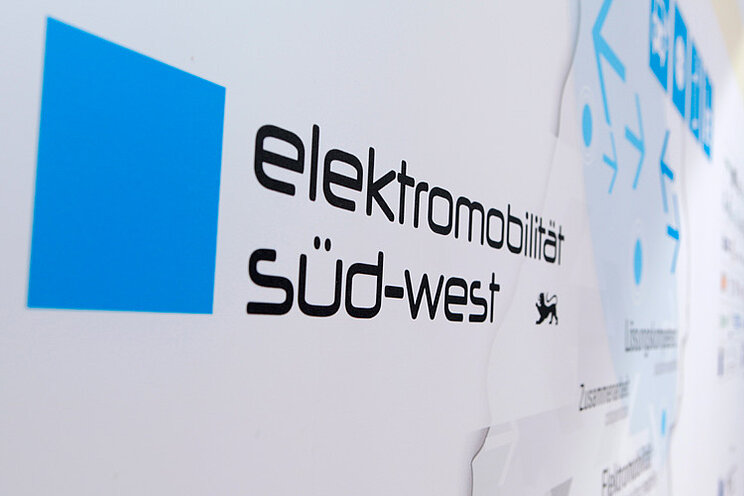 Auf einer Messewand ist das Logo vom Cluster Elektromobilität Süd-West