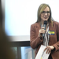 Katja Gicklhorn, e-mobil BW, hält ein Mikrofon in der Hand und hält einen Vortrag.