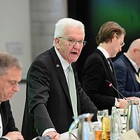 Ministerpräsident Winfried Kretschmann spricht bei einer Veranstaltung ins Mikrofon.