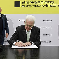 Ministerpräsident Winfried Kretschmann unterzeichnet eine gemeinsame Absichtserklärung.