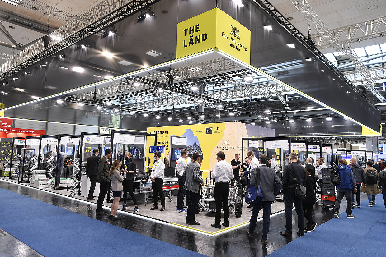 Baden-Württemberg Pavillon auf der Hannover Messe 2022 Blick auf den Gemeinschaftsstand des Landes Baden-Württemberg. Der Schriftzug 'THE LÄND' und das Landeswappen sind gut sichtbar. Viele Menschen informieren sich auf der Fläche.