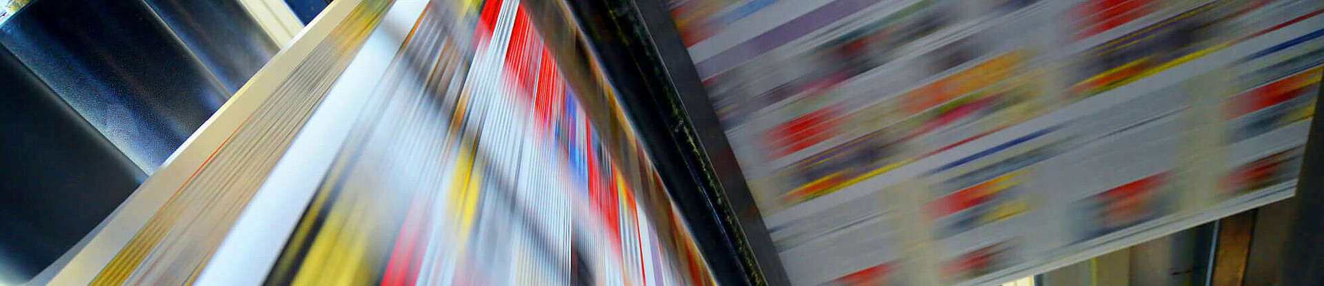 Druckpapier einer Zeitung läuft über eine Walze.