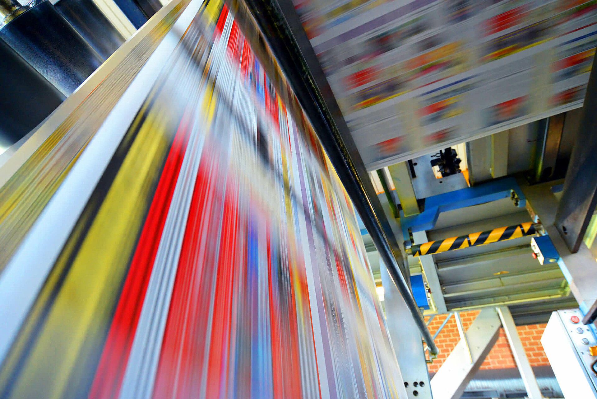 Druckpapier einer Zeitung läuft über eine Walze.